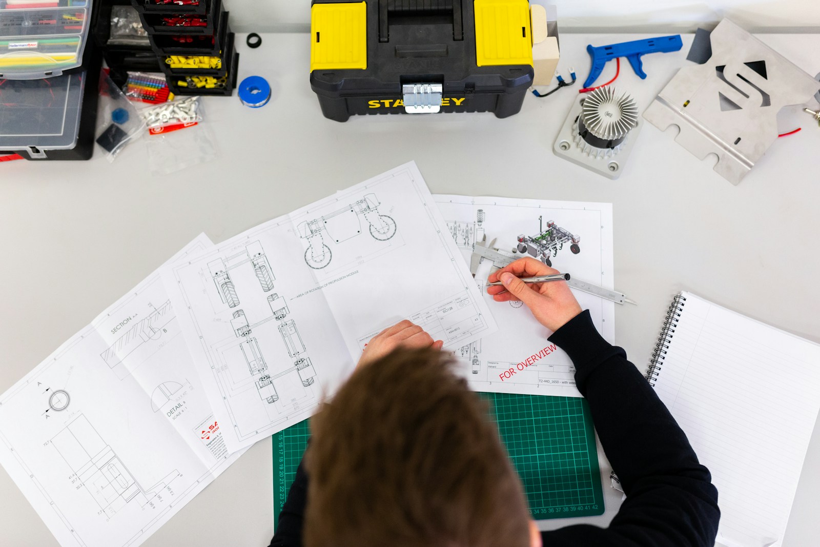 Fotografia ilustrativa de uma pessoa analisando desenhos técnicos de engenharia